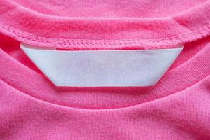 etiqueta de ropa en blanco para el cuidado de la ropa en la camisa rosa foto