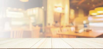 Wood table top with Restaurant cafe or coffee shop interior with people abstract defocused blur background photo
