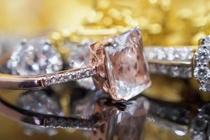 joyas de oro de lujo, diamantes y anillos de topacio rosa con reflejo en el fondo negro foto