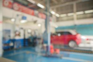 Red car lift at maintenance station in automotive service center blur abstract background photo