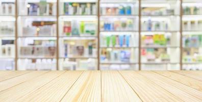 Pharmacy wood table counter with medicines healthcare product arranged on shelves in drugstore blurred defocused background photo