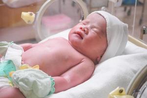 new born baby infant sleep in the incubator at hospital photo