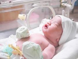 newborn baby infant sleep in the incubator at hospital photo