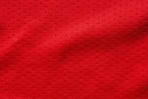 Red fabric sport clothing football jersey with air mesh texture background photo