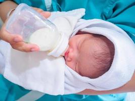 Mother feeding newborn baby from the bottle photo