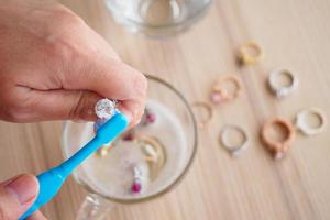 Jeweller hand cleaning and polishing vintage jewelry diamond ring closeup photo