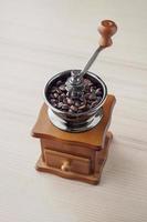 Vintage manual coffee grinder with roasted coffee beans photo