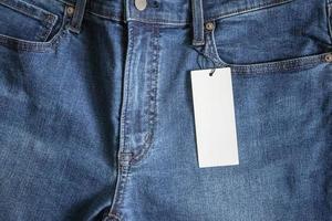 jeans azules con etiqueta de precio blanca en blanco foto