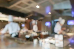 Chef cooking in restaurant kitchen abstract blurred defocused background photo