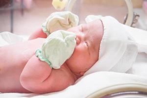 new born baby infant sleep in the incubator at hospital photo