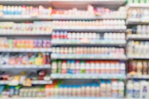 Abstract blur supermarket grocery store refrigerator shelves with fresh milk bottles and dairy products photo