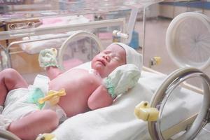 new born baby infant sleep in the incubator at hospital photo