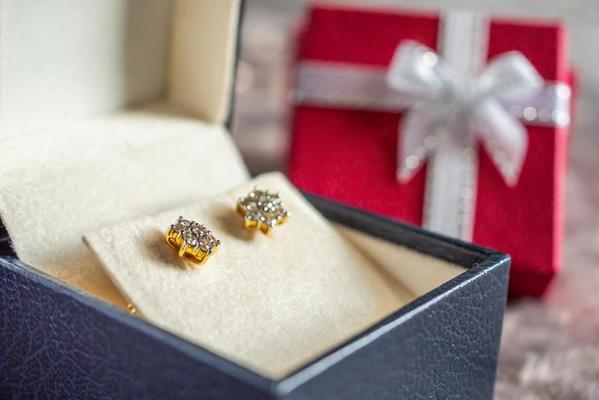 Jewelry gold diamond earring with gift box background