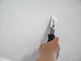 yesero mano reparación grieta pared blanca foto