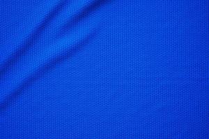 Blue football jersey clothing fabric texture sports wear background, close up top view photo