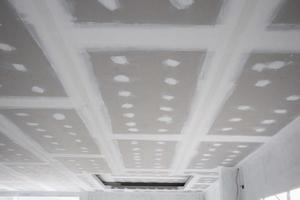 ceiling gypsum board installation at construction site photo