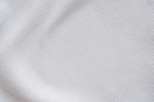 White fabric sport clothing football jersey with air mesh texture background photo