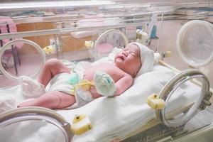 new born baby infant sleep in the incubator at hospital photo