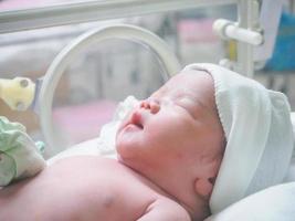 newborn baby infant sleep in the incubator at hospital photo