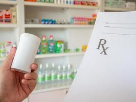 female pharmacist with prescription and medicine at the pharmacy photo