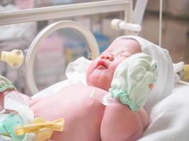 new born baby infant sleep in the incubator at hospital photo