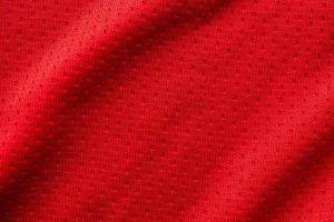 Red fabric sport clothing football jersey with air mesh texture background photo