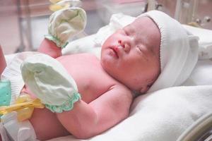 bebé recién nacido duerme en la incubadora del hospital foto
