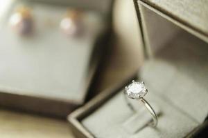 anillo de diamantes en caja de regalo de joyería en mesa de madera foto