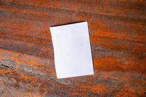 Blank white paper on old rustic wood table background photo