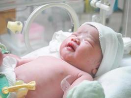 new born baby infant sleep in the incubator at hospital photo