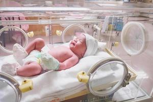 new born baby infant sleep in the incubator at hospital photo