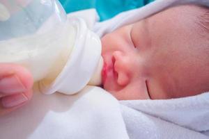 Mother feeding newborn baby from the bottle photo