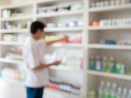 blur pharmacist taking medicine from shelf in the pharmacy photo