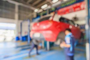 Red car lift at maintenance station in automotive service center blur abstract background photo