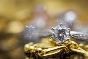 anillos de diamantes de joyería de oro de lujo con reflejo en el fondo negro foto