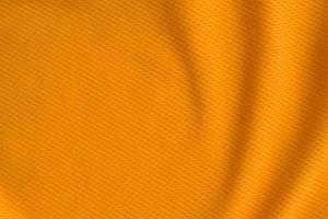 vista superior de textura de camiseta de fútbol de jersey de tela de ropa deportiva de color naranja foto