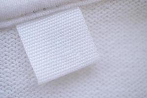 Blank white clothes label on new shirt background photo