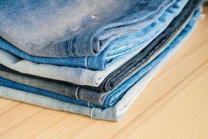 denim blue jeans stack on wood table background photo