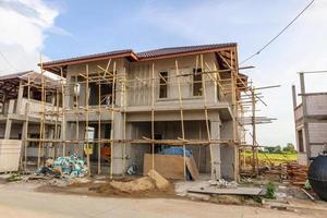 construction residential new house in progress at building site with clouds and blue sky photo