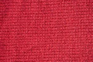 Red knitted wool fabric texture background photo