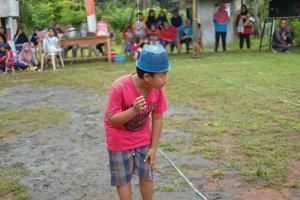 blitar, indonesia - 11 de septiembre de 2022 un niño pequeño con una camisa roja que está muy feliz de participar en la competencia para animar el día de la independencia de indonesia en blitar foto