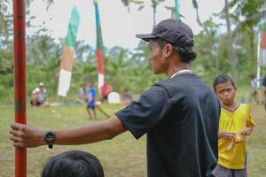 Blitar, indonesia - September 11th 2022 A picture of a man in a black hat and shirt photographed from the side who is watching something photo