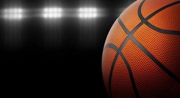 Basketball on a black background under stadium lights photo