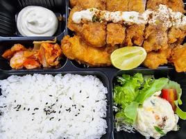 japanese set box fried food with salad and lemon. chicken bento jasmin rice. photo