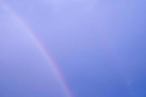 curve multi color double rainbow on blue sky. abstract pastel light on hogh air on climate after rain fallen. photo