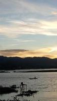 silueta de un hombre pescando por la tarde. puesta de sol en el lago limboto, indonesia foto