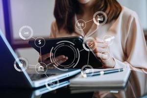 businesswoman working with mobile phone and tablet and laptop computer Internet with Augmented Reality on VR dashboard on desk in modern office photo