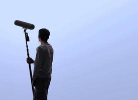 operador de boom de sonido grabando sonido por micrófono fisher para película ambientada en un estudio. foto