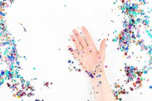 Woman hand with festive color star confetti photo