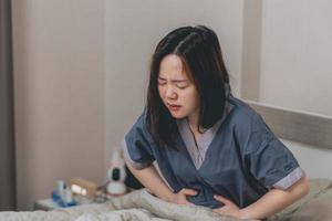 Asian women have stomach pain or menstruation in bedroom photo